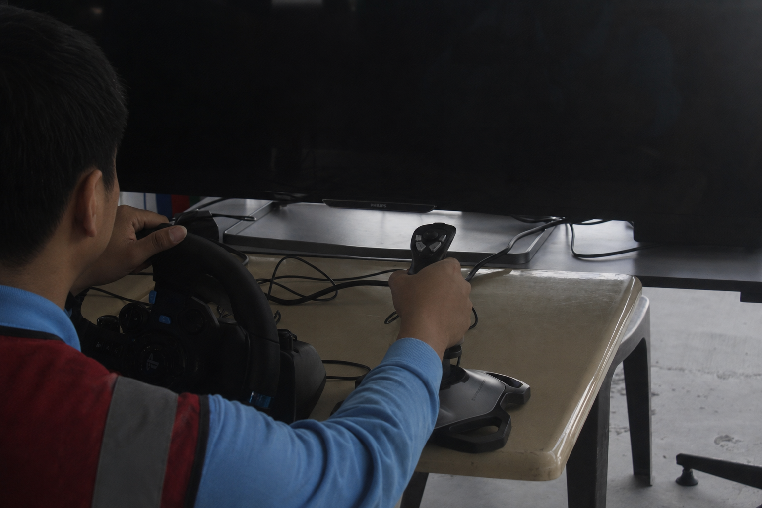 Visitor trying the forklift simulator with steering wheel and joystick controller